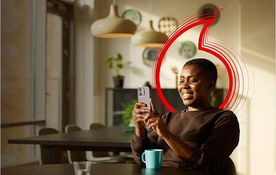 A woman holding a mobile phone, smiling. 
