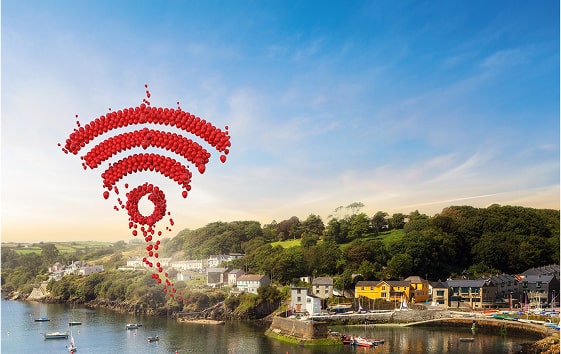 A red Wi-Fi symbol made of balloons featuring the Vodafone logo hovers above a serene river